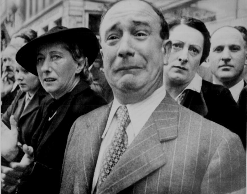 A Frenchman weeps as German soldiers march into Paris