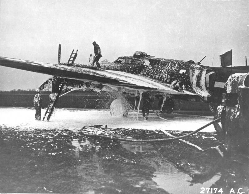 Ground crew extinguishing fire aboard B-17 Flying Fortress bomber 'Meat Hound'