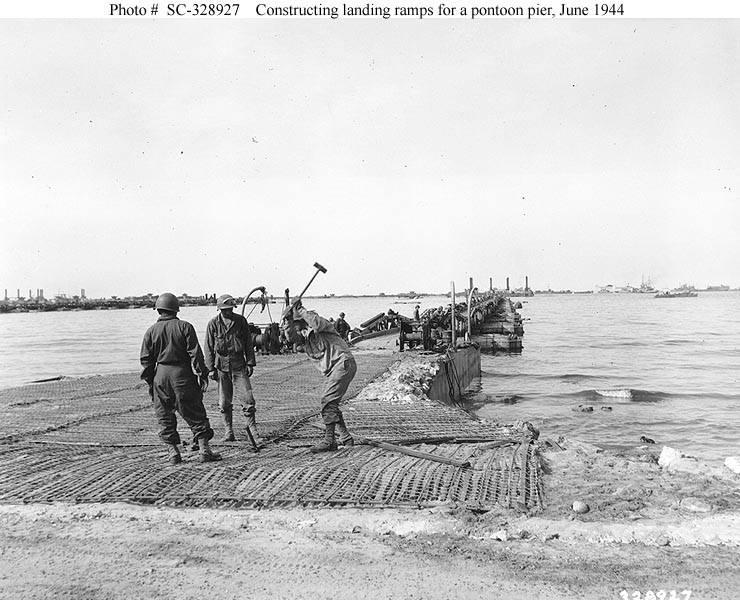U.S. Soldiers construct a landing ramp as part of the Mulberry "A" artificial harbor at "Omaha" Beach.