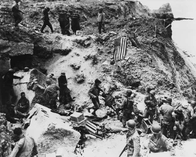 Hands clasped over their heads, a group of German prisoners