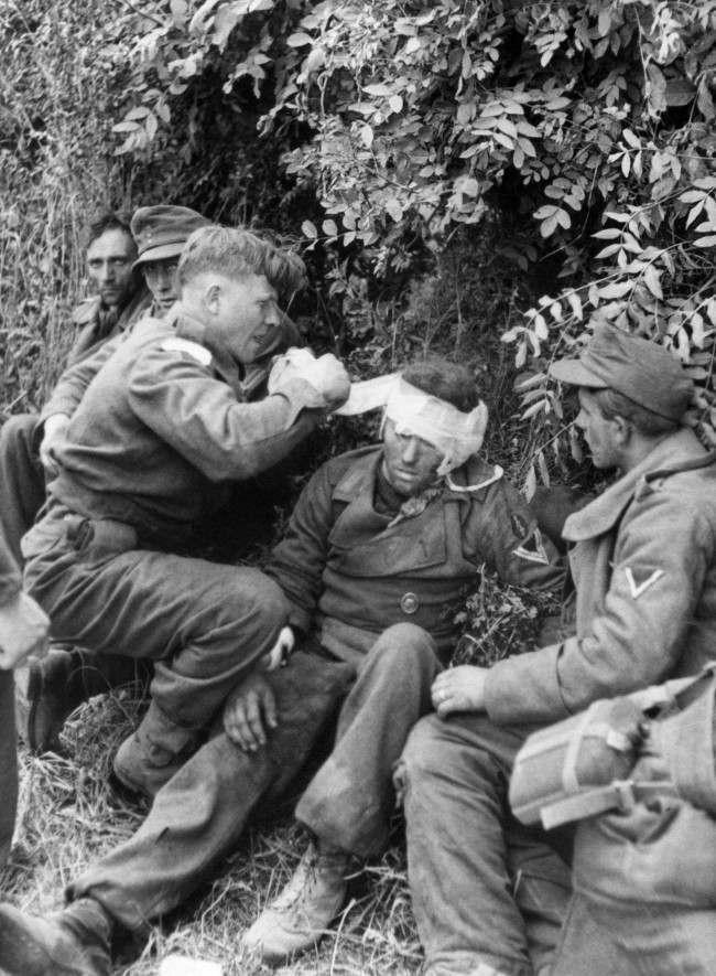 A stretcher bearer attends to a wounded German